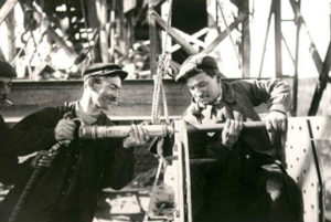 Ouvriers réalisant le rivetage avec un marteau pneumatique et une bouterolle et un tas